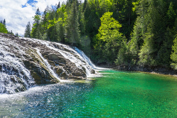 View on the beautiful emerald and transparent water of the Chute de La riviere aux Emeraudes near...