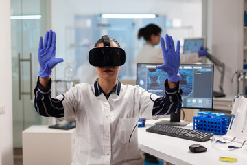 Biochemist doctor experiencing virtual reality wearing headset during vaccine experiment. Team of researchers working with equipment device, future, medicine, healthcare, professional, vision