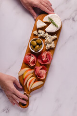Serving board with meat and cheese snacks.