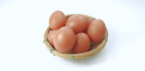 Several chicken eggs are laid in bamboo baskets isolated on white background. Product idea from a chicken farm owner