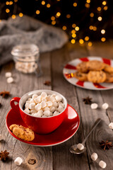 Hot chocolate with marshmallow in red cup on wooden table