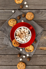 Flat lay top view hot chocolate with marshmallow in red cup on wooden table
