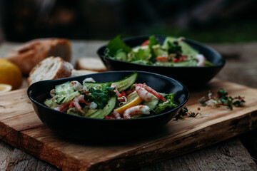 salad with seafood, avocado and herbs on a wooden background