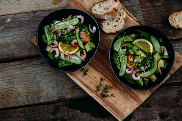 salad with seafood, avocado and herbs on a wooden background