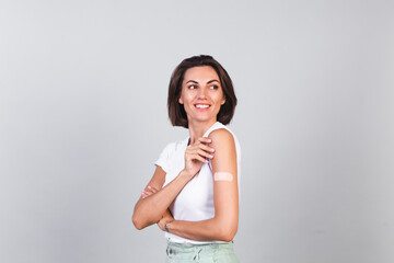 Young woman after vaccination Showing Arm With Plaster Bandage. Virus protection. COVID-2019.