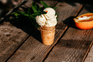 orange ice cream in a waffle cup on a wooden background