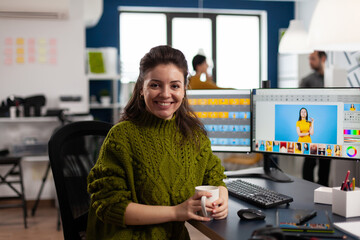 Woman retoucher looking at camera smiling sitting in creative media agency retouching client photos...