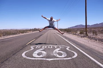 Rugzak happy man jumping in the middle of the road, on route 66 © jordi