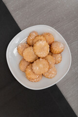 Vertical frame. Appetizing sand cookies on white plate. Homemade shortcake. Top view