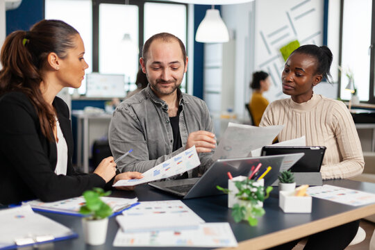 Team of diverse startup company colleague entrepreneur meeting in professional workplace, brifing and sharing ideas over financial strategy management. Multiracial business people working together.