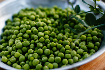 peas in a plate on a wooden background