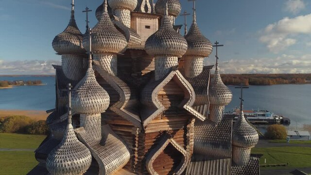 Beautiful aerial details wooden no nails old Kizhi Karelia traditional church. Russia historical landmark tample on island in lake. Dome cross, facade. Sunny day. Beautiful gold ring travel best movie