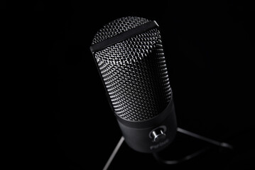 Studio microphone on dark background with copy space. Black professional condencer microphone....