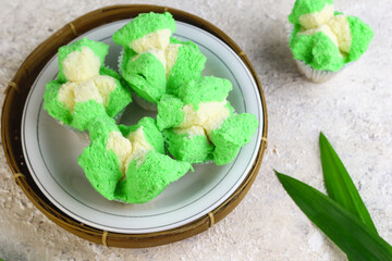 Bolu Kukus Pandan or Flower bloom steam cake, Indonesian traditional cake, with pandan leaves flavour. White bright background. Morning tea concept. - obrazy, fototapety, plakaty