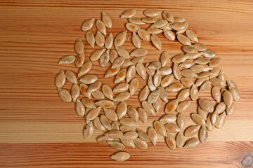 Dried pumpkin seeds on a wooden background close-up