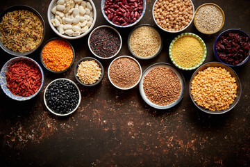 Various superfoods in smal bowls on dark rusty background