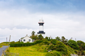 Fototapeta na wymiar Lighthouse on Inishowen peninsula in North Ireland. Beautiful Wild Atlantic Way with typical irish landscapes, coastline and cliffs.