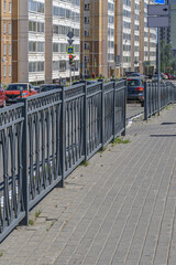 Metal fencing of the roadway on a summer day