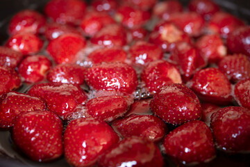 Preparing strawberry marmalade in a metallic pan.