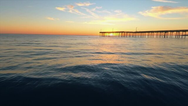 Aerial: Calm water at sunset at the beach. Pismo Beach