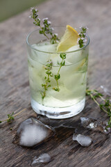 Iced tea with thyme and lemon in a glass
