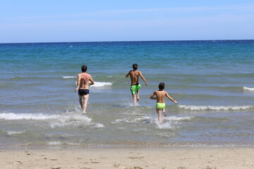Tata i synowie podczas wygłupów na plaży. Dad and sons on the beach.