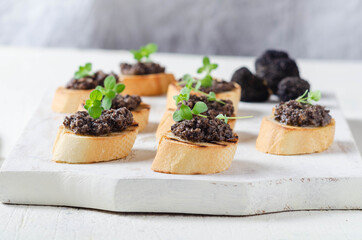 Italian black truffle bruschetta with herbs on grilled bread.