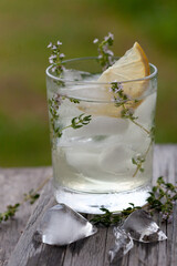 Iced tea with thyme and lemon in a glass