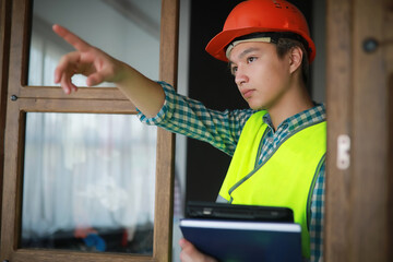 Asian man in protective helmet and construction waistcoat