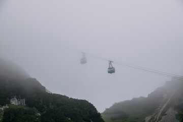 Kabinen einer Seilbahn im dichten Nebel
