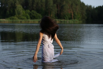 Young woman in white dress in the lake