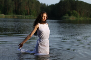 Young woman in white dress in the lake
