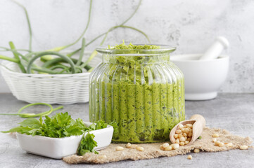 Homemade organic pesto sauce made from fresh arrows of garlic,dill and oil in a glass jar.