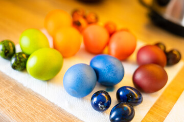 Freshly painted colorful easter chicken and quail eggs lie in the kitchen