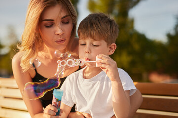 Mother and kid blowing soap bubbles