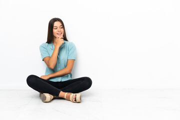 Teenager girl sitting on the floor looking to the side