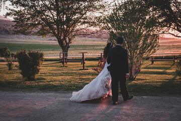 bride and groom walking in the park