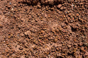 Cobbles background, granite wall. Small stones, Gravel. Sandy stones. Brown and orange. Light-brown stone , rock , gravel texture.