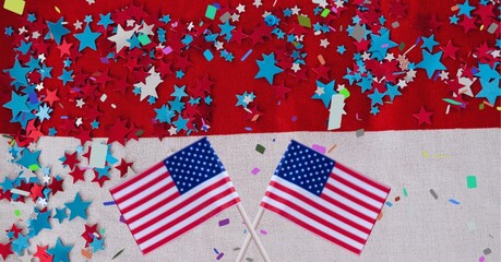 Fototapeta na wymiar Composition of crossed american flags, over confetti and stars, on red and white
