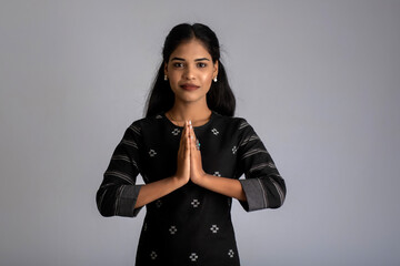 Beautiful Indian girl with welcome expression or inviting or greeting Namaste