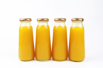 Fresh fruit juice in small glass bottles on a white background.Empty front area for branded labels for beverage design.Orange juice,mango, mandarin, apricot,peach,persimmon, pumpkin, sea buckthorn