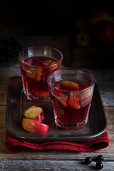 Natural compote of currant berries and apples in glass glasses on a metal tray, selective focus
