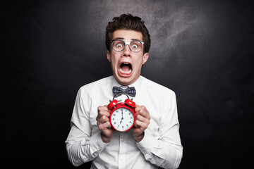 Funny man showing alarm clock and screaming