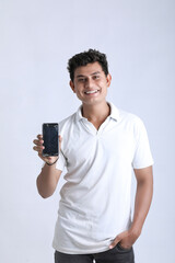 Young indian man showing smartphone on white background