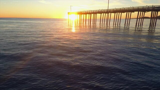 Aerial: Calm water at sunset at the beach. Pismo Beach