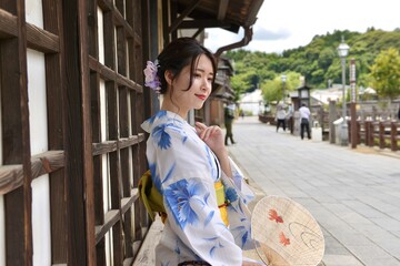小江戸佐原の町並みで団扇を手に微笑む浴衣姿の若い女性	