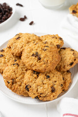 Homemade oatmeal cookies with raisins in a white plate on a light background closeup	
