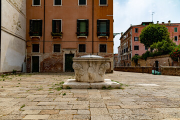 Fototapeta na wymiar An ancient water well on a square in Venice, Italy