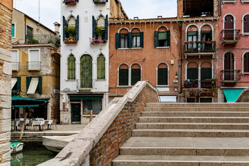Fototapeta na wymiar Romanic view of a Water Canal (so-called Riva) in Venice, Italy. These waterways are the main means of transport in the city