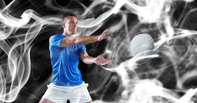 Composition of male rugby player catching rugby ball on black background
